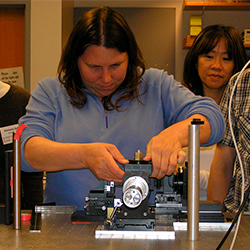 Instructor working on flow cytometer optical bench, c. 2008